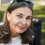 Beauty, aging, maturity, style and fashion concept. Close up portrait of carefree beautiful middle aged female pensioner in stylish clothes relaxing outdoors in park, her look full of wisdom and joy