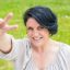 Joyful happy middle aged woman showing peace sign. Cheerful Caucasian lady standing outdoors and making victory gesture. Peace concept